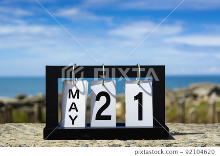May 21 calendar date text on wooden frame with blurred background of ocean. May 21 calendar date text on wooden frame with blurred background of ocean. 92104620