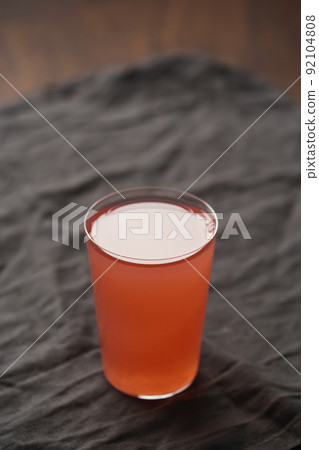 Organic guava drink in thin glass on wood table Organic guava drink in thin glass on wood table 92104808