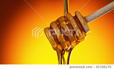 Honey dripping from wooden dripper. Honey dripping from wooden dripper. 92106270