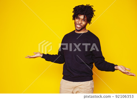 Young handsome african american guy student posing cheerful and gesturing on yellow background, lifestyle people concept close up 92106353