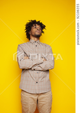 Young handsome african american guy student posing cheerful and gesturing on yellow background, lifestyle people concept close up Young handsome african american guy student posing cheerful and gesturing on yellow background, lifestyle people concept close up 92106355