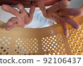 A man puts his hands inside a brown pet carrier basket. Adult male wants to get a cat or puppy out of a plastic carrier. Inside view. Selective focus. 92106437