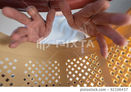 A man puts his hands inside a brown pet carrier basket. Adult male wants to get a cat or puppy out of a plastic carrier. Inside view. Selective focus. A man puts his hands inside a brown pet carrier basket. Adult male wants to get a cat or puppy out of a plastic carrier. Inside view. Selective focus. 92106437