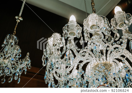 Beautiful czech crystal chandeliers on ceiling in dark night. Glass crystals hanging on vintage Beautiful czech crystal chandeliers on ceiling in dark night. Glass crystals hanging on vintage 92106824