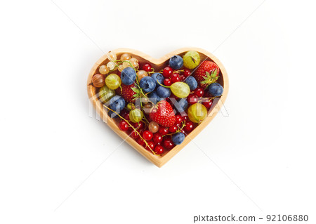 Berries mix in in a heart shaped bowl on white background 92106880
