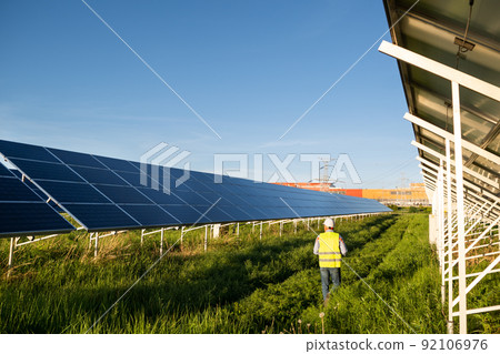 Worker in solar farm. Solar photovoltaic panels. Solar energy. Eco concept Worker in solar farm. Solar photovoltaic panels. Solar energy. Eco concept 92106976