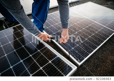 Worker installing solar energy panels. connect two panel together. eco concept Worker installing solar energy panels. connect two panel together. eco concept 92106983