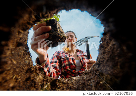 Female gardener planting. View from underground. 92107036