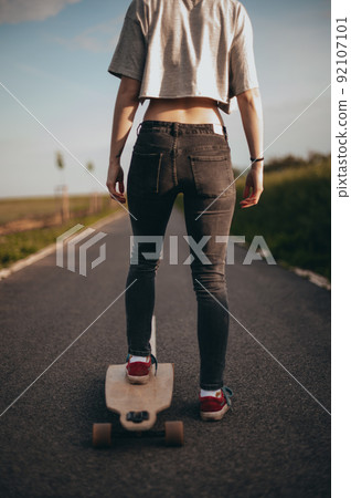 beautiful girl stands on a longboard one leg.poster, vertical banner, anonymous photography. faceless . Sunny day . beautiful girl stands on a longboard one leg.poster, vertical banner, anonymous photography. faceless . Sunny day . 92107101