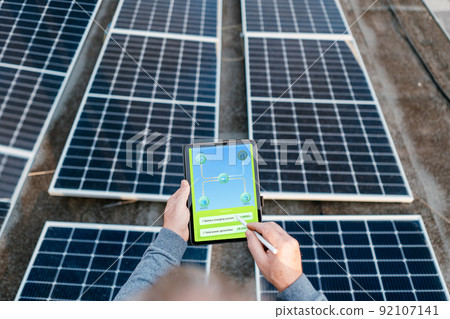 Engineer using solar system application. Checking solar panel setup. Engineer using solar system application. Checking solar panel setup. 92107141