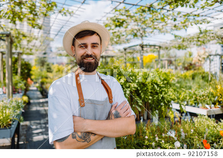 Male worker in garden centre looking at camera.  92107158