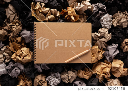 Notepad or notebook on crumpled paper balls as background texture. Inspiration idea concept Notepad or notebook on crumpled paper balls as background texture. Inspiration idea concept 92107456