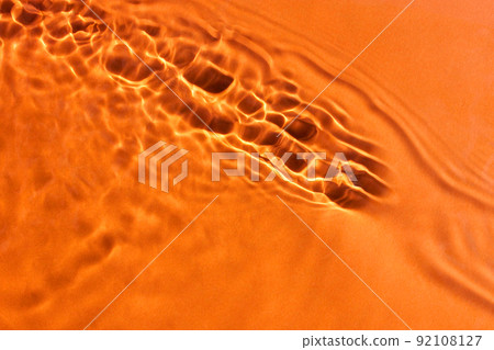 Clear water surface texture with waves. Orange background. Hot summer concept. Clear water surface texture with waves. Orange background. Hot summer concept. 92108127