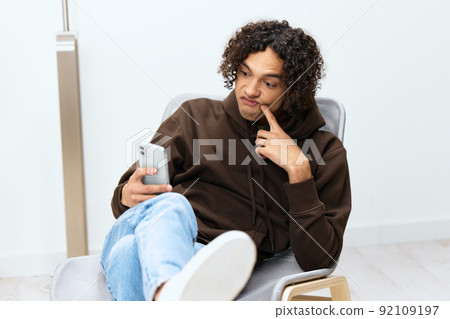 handsome guy chatting in the room on the phone light background handsome guy chatting in the room on the phone light background 92109197