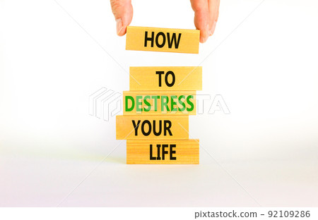 Destress your life symbol. Concept words How to destress your life on wooden blocks. Doctor hand. Beautiful white background. Psychological business and destress your life concept. Copy space. 92109286