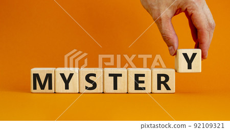 Mystery symbol. The concept word Mystery on wooden cubes. Beautiful orange table, orange background, copy space. Businessman hand. Business and mystery mysterious concept. Mystery symbol. The concept word Mystery on wooden cubes. Beautiful orange table, orange background, copy space. Businessman hand. Business and mystery mysterious concept. 92109321