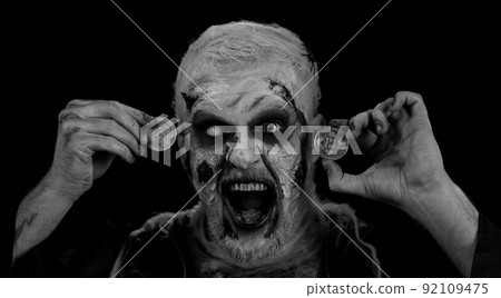 Crazy man with bloody scars face, Halloween zombie showing golden bitcoins mining future technology 92109475