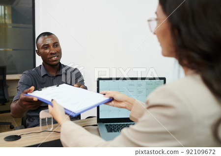 Manager Giving Form to Applicant Manager Giving Form to Applicant 92109672