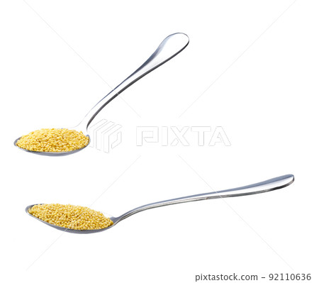 metal spoon with grains of millet isolated on white background. metal spoon with grains of millet isolated on white background. 92110636