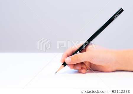 Child's hand holding a pencil 92112288