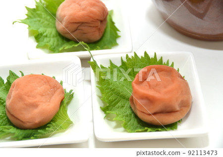 A small plate with one pickled plum on top of shiso A small plate with one pickled plum on top of shiso 92113473