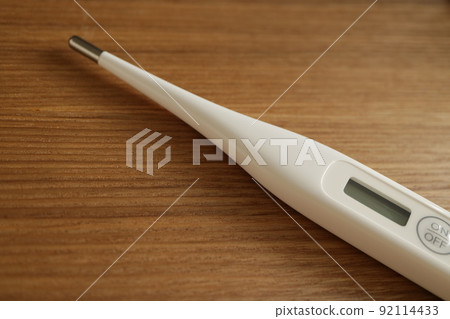 A simple white thermometer placed on the desk A simple white thermometer placed on the desk 92114433