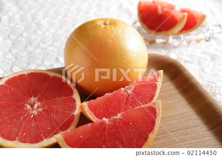 Lots of grapefruits, cut pink grapefruits, multiple grapefruits 92114450