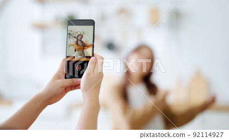 Young asian womans shooting together dancing in kitchen at house when making video for social media Young asian womans shooting together dancing in kitchen at house when making video for social media 92114927