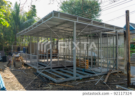 underconstruction housemaid small temporary home is made from steel pole structure without cement and brick with garden and fence around. 92117324