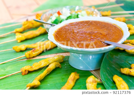 grilled Satay pork, Thailand traditional popular food stick with wood strick, cooked ready to eat with specific sauce beside. grilled Satay pork, Thailand traditional popular food stick with wood strick, cooked ready to eat with specific sauce beside. 92117376