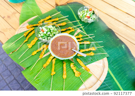 grilled Satay pork, Thailand traditional popular food stick with wood strick, cooked ready to eat with specific sauce beside. grilled Satay pork, Thailand traditional popular food stick with wood strick, cooked ready to eat with specific sauce beside. 92117377