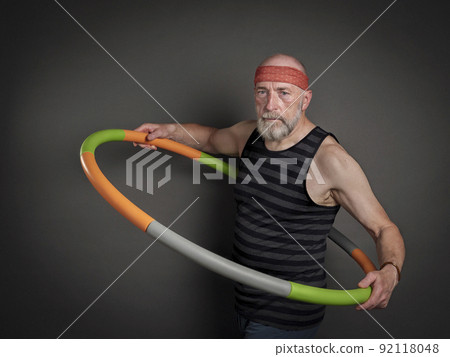 senior man is exercising with a weighted hula hoop senior man is exercising with a weighted hula hoop 92118048