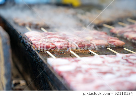 Grilled square beef sticks (Japanese) are arranged on the big pan plate with smoke around. 92118184