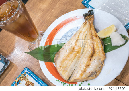 Japanese cooked fish in dish on wood table at Japanese restaurant 24 hours open. Japanese cooked fish in dish on wood table at Japanese restaurant 24 hours open. 92118201