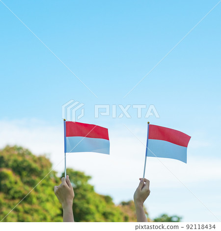 hand holding Indonesia flag on blue sky background. Indonesia independence day, National holiday Day and happy celebration concepts hand holding Indonesia flag on blue sky background. Indonesia independence day, National holiday Day and happy celebration concepts 92118434