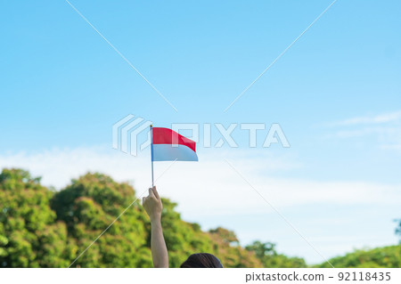 hand holding Indonesia flag on blue sky background. Indonesia independence day, National holiday Day and happy celebration concepts hand holding Indonesia flag on blue sky background. Indonesia independence day, National holiday Day and happy celebration concepts 92118435