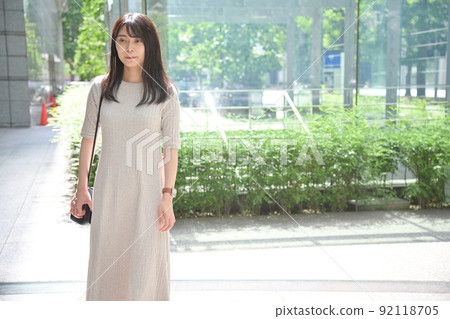 A young woman standing on the street corner 92118705