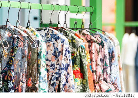 Colorful flower pattern women's clothes hang on to green clothes line in the Asia - Korea fashion shop. Colorful flower pattern women's clothes hang on to green clothes line in the Asia - Korea fashion shop. 92118815