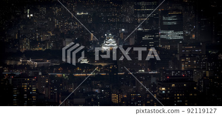Osaka Castle illuminated at night in panorama / birdeye or top view with cityscape and high building around, Osaka Prefecture, Japan. 92119127
