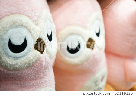 Pretty pink owl dolls in the row on the shelf. Ready for sales., Thailand. 92119139