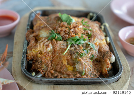 Fresh Oyster Omelette on the black hot plate / pan ready to eat. 92119140