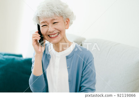 Senior woman receiving fun news [smartphone] 92119866