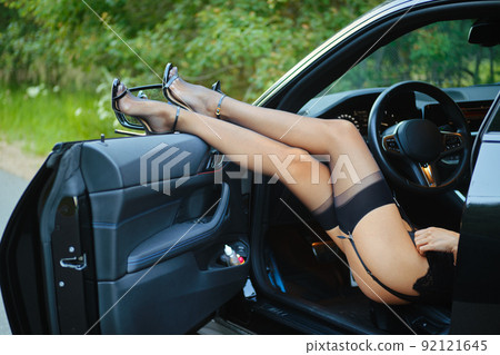Female legs in stockings the opened door of the car Female legs in stockings the opened door of the car 92121645