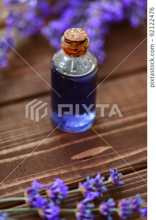 Herbal lavender oil bottle with flowers on wooden background 92122476
