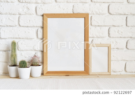 Square wooden photo frame and cactus plants on the table Square wooden photo frame and cactus plants on the table 92122697