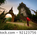Women in Thai national costumes  With the red umbrella standing in front of the main door, the time of waiting, the past image, the time gate  Translation at the door is the name 92123756