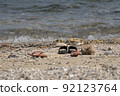Travelers take off casual shoes on the beach by the sea to swim. 92123764