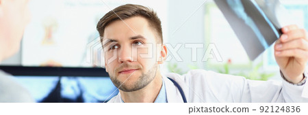 Smiling doctor talking with patient about good x ray results Smiling doctor talking with patient about good x ray results 92124836