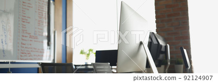 Empty office, computers on desks, light room for company employees 92124907