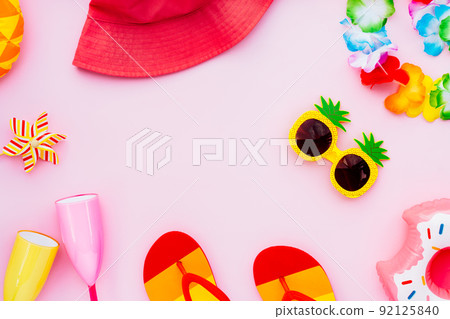 Flat lay of summer vibes concept with colorful pool party items, funny sunglasses, cocktail glasses. inflatable drink holders, flip flops, bucket hat, flower necklaces on pink background. Copy space Flat lay of summer vibes concept with colorful pool party items, funny sunglasses, cocktail glasses. inflatable drink holders, flip flops, bucket hat, flower necklaces on pink background. Copy space 92125840